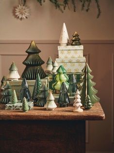 a table topped with lots of different types of christmas trees and ornaments on top of it