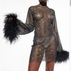 a woman in a bodysuit with feathers on her arms and legs, posing for the camera