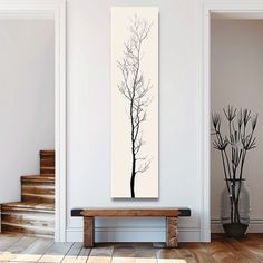 a black and white photo of a tree on a wall in a room with stairs