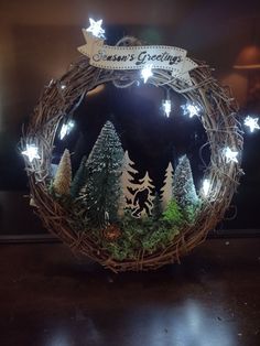 a lighted wreath with trees and stars on it