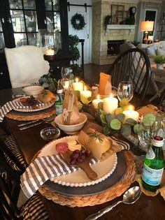 the table is set with cheese, wine and candles for an appetizing party