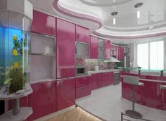 this kitchen has pink cabinets and white counter tops, along with an aquarium in the center