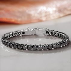 Introducing the King Cobra Tennis Bracelet, a blend of mystique and majesty in 14K white gold. This captivating piece features 10 carats of elevated black diamonds, each radiating a captivating, deep hue. The round-cut diamonds add classic elegance, creating a harmonious balance with the bracelet's enigmatic charm. More than just an accessory, the King Cobra is a symbol of sophistication and strength, perfect for those who cherish unique elegance and celestial allure.Diana Rafael's Black Ice col Black Diamond Necklace, Black Diamond Studs, White Diamond Earrings, Black Diamond Earrings, King Cobra, Black Diamond Engagement, Halo Necklace, Black Ice, Gold Ring Designs