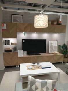 a living room filled with furniture and a flat screen tv on top of a wall