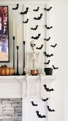 a mantle with candles and decorations on it in front of a fireplace decorated for halloween