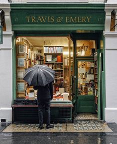 a person holding an umbrella in front of a book store