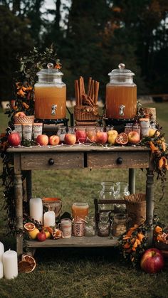 an old wooden table topped with jars filled with liquid and fruit on top of it