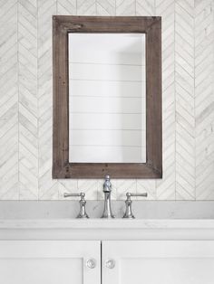 a bathroom sink with a mirror above it and two faucets on the side