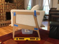 a couch is taped up and placed on the floor in front of a fire place