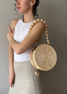 Introducing the perfect handmade straw handbag for summer Wicker Round Bag! The classic round purse shape features a natural wooden beads handle with metal gold chain and can be a removable if you need. This amazing hand woven circle straw crossbody bag with shoulder gold chain bring chic Provençal flair to summer get-ups and to take from the beach to the city in years to come. Designed with beige textile lining inside to hold in safe your essentials. Diameter 20 cm. Shoulder wooden beads strap Beads Strap, Straw Crossbody Bag, Summer Handbag, Round Straw Bag, Women's Mittens, Handwoven Bag, Round Purse, Summer Handbags, Unique Hats