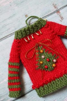 a knitted christmas sweater with a tree on it sitting on top of a wooden table