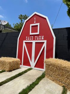 a red barn with hay bales in front of it and the words, mai's farm