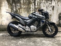 a black and silver motorcycle parked in front of a wall