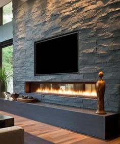 a living room with a large stone fireplace and flat screen tv mounted on the wall