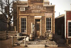 an old western store with barrels and wooden steps leading up to the front door that says general store