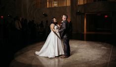 a bride and groom standing on a dance floor in front of an audience at their wedding reception