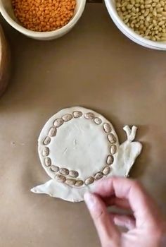 a person is making a cookie with beads and sprinkles on the table