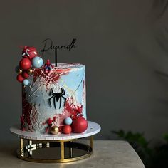 a spiderman birthday cake with decorations on the top and bottom, sitting on a table