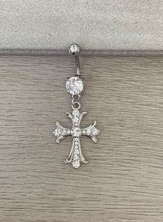 the cross is attached to an earring with crystal stones on it's side