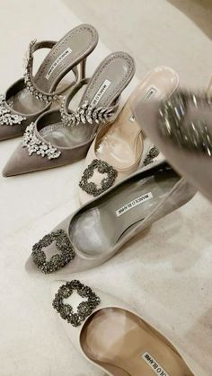 several pairs of women's shoes on the floor with their heels covered in jewels