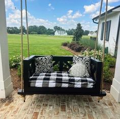 a black and white checkered pillow on a porch swing