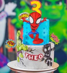 a spiderman birthday cake with the number three on it's top and decorations