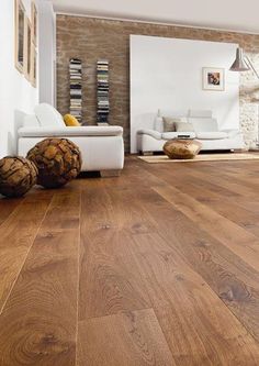 a living room with wood floors and white furniture on the floor is pictured in this image