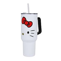 a white hello kitty travel mug with a red bow on the lid and black handle