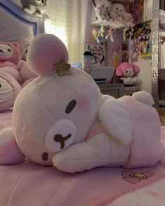 a large white teddy bear laying on top of a pink bed covered in stuffed animals