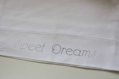 the words sweet dreams are embroidered on white linens