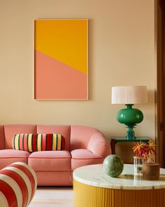 a living room filled with furniture and a painting hanging on the wall above it's coffee table