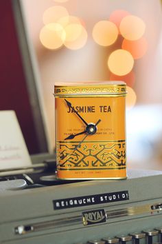 a tea tin sitting on top of an old typewriter