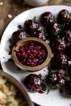 cranberry sauce is in a wooden spoon on a white plate next to other dishes