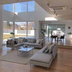 a living room filled with furniture and large windows