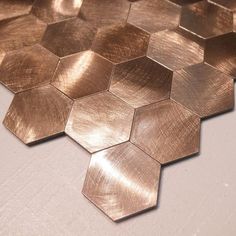 some metallic hexagons on a white surface with no one around them or in the background