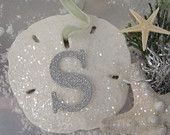 a snowman ornament with the letter s on it next to a christmas tree