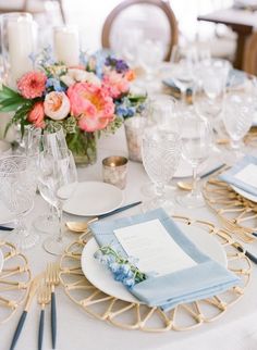 the table is set with place settings and flowers