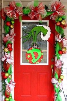 a red door decorated with christmas decorations and an elf's head on top of it