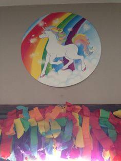 there is a unicorn painted on the wall next to a window with colorful streamers