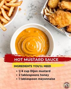 hot mustard sauce in a white bowl next to some fried chicken and french fries on a marble table