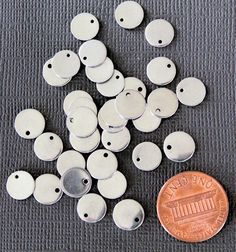 a penny sitting on top of a table next to some metal buttons