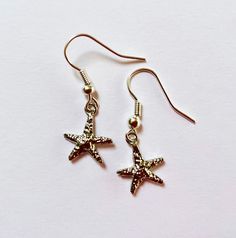 silver starfish earrings | perfect gift for someone who loves the beach! - select style: 2" chain, 1" chain, or no chain - the chain is silver plated - the starfish is silver plated, 12x13 mm - silicone earring backs Matching necklace (not included) shown in the 7th photo listed here: https://www.etsy.com/listing/1761083009/silver-plated-chain-y-necklace-with Matching bracelet (not included) shown in the last photo listed here: https://www.etsy.com/your/shops/me/listing-editor/edit/1746880550 💌 Silver Starfish Charm Jewelry For Summer, Silver Ocean-inspired Earrings With Starfish Charm, Ocean-inspired Silver Earrings With Starfish Charm, Summer Starfish Charm Star-shaped Jewelry, Summer Starfish Charm Star Shaped Jewelry, Silver Jewelry With Starfish Charm For Summer, Summer Star-shaped Starfish Charm Jewelry, Nickel Free Silver Starfish Earrings, Nickel-free Silver Starfish Earrings