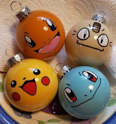 four different colored ornaments with faces on them