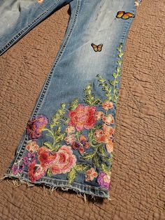 a pair of jeans with flowers and butterflies painted on them