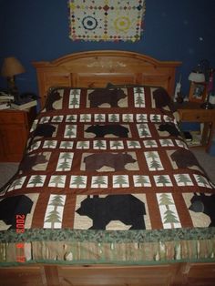 a bed with a brown bear quilt on it's headboard and foot board