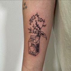 a black and white photo of a flower in a box tattoo on the left arm