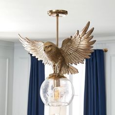 a golden bird figurine hanging from a chandelier