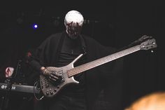 a man with white hair is holding a silver guitar in front of him on stage