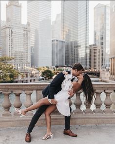 a man and woman kissing in front of the chicago skyline