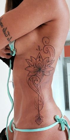 a woman with a tattoo on her stomach and side view mirror in the back ground